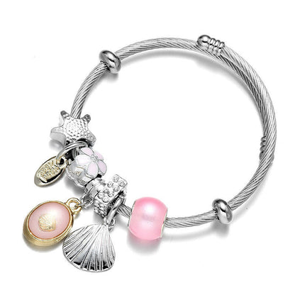 Silver wrap bangle bracelet with pink bead and seashell charm accents