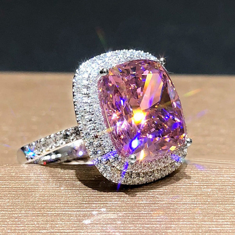 Silver-toned halo ring with cushion-cut pink gemstone, angled view