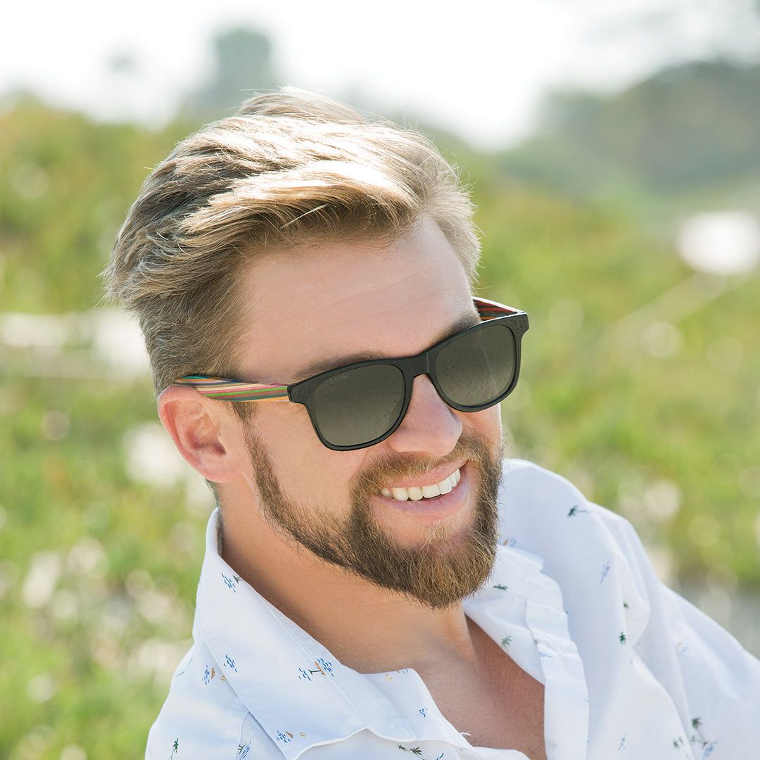 Man wearing black bifocal sunglasses with rainbow striped temple arms