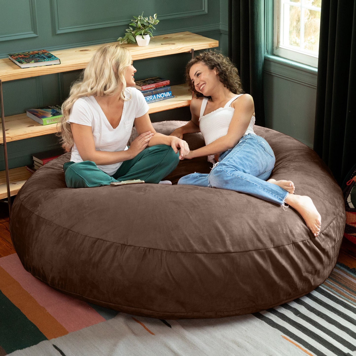 Dark brown cocoon bean bag chair with wide, rounded cushion seating two people