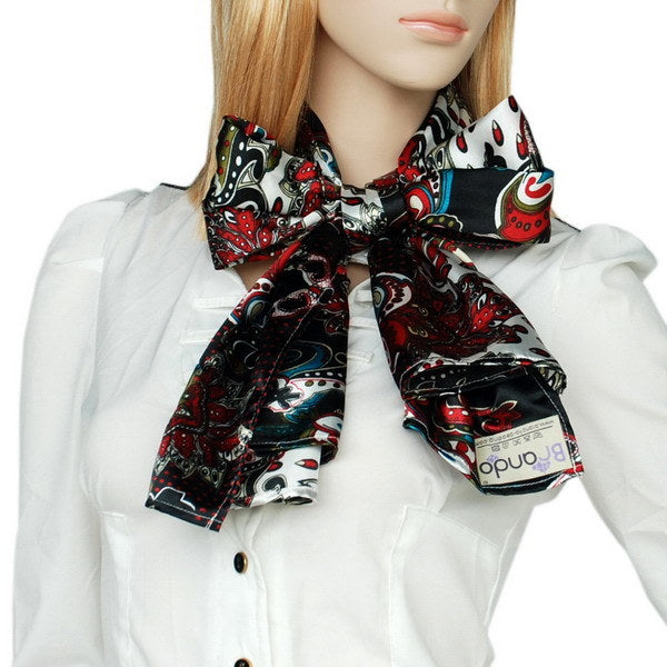Paisley scarf with red, teal, and white patterns on dark base, tied at the neck.