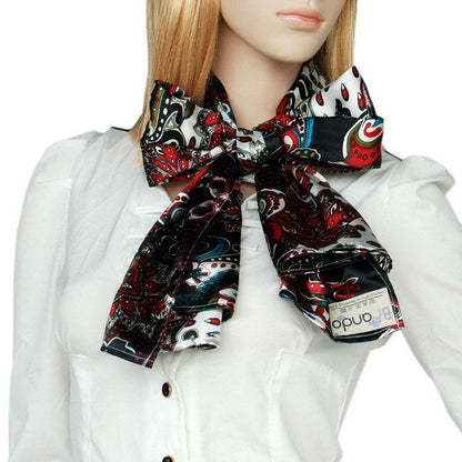 Paisley scarf with red, teal, and white patterns on dark base, tied at the neck.
