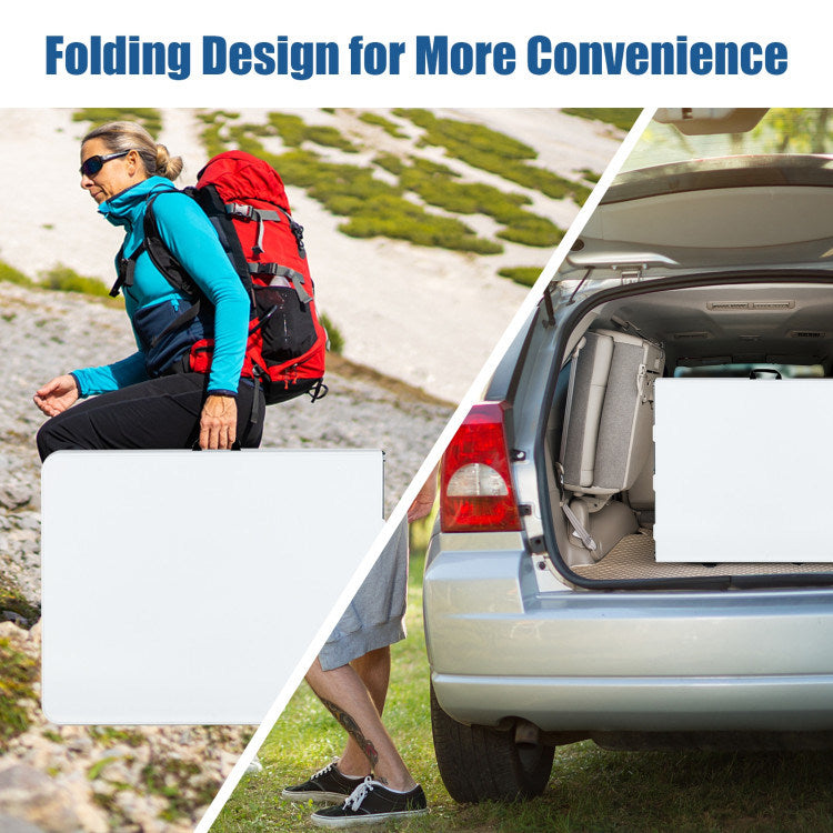 Folded white portable camping table with carry handle, stored in a car trunk