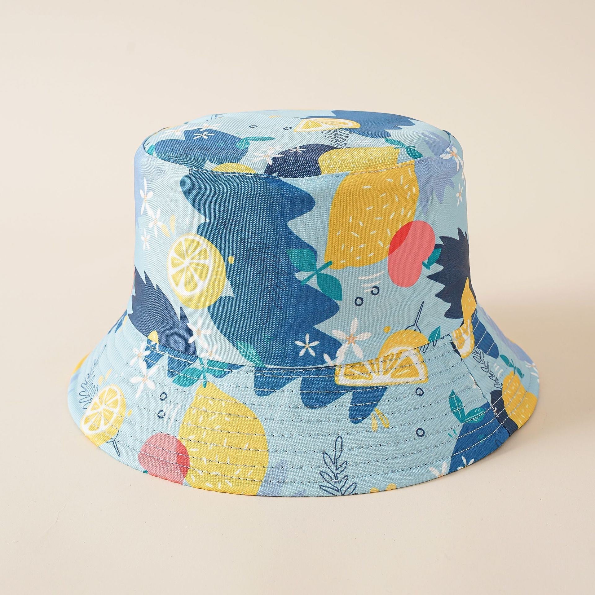 Double-sided fisherman bucket hat in light blue with lemon and fruit print