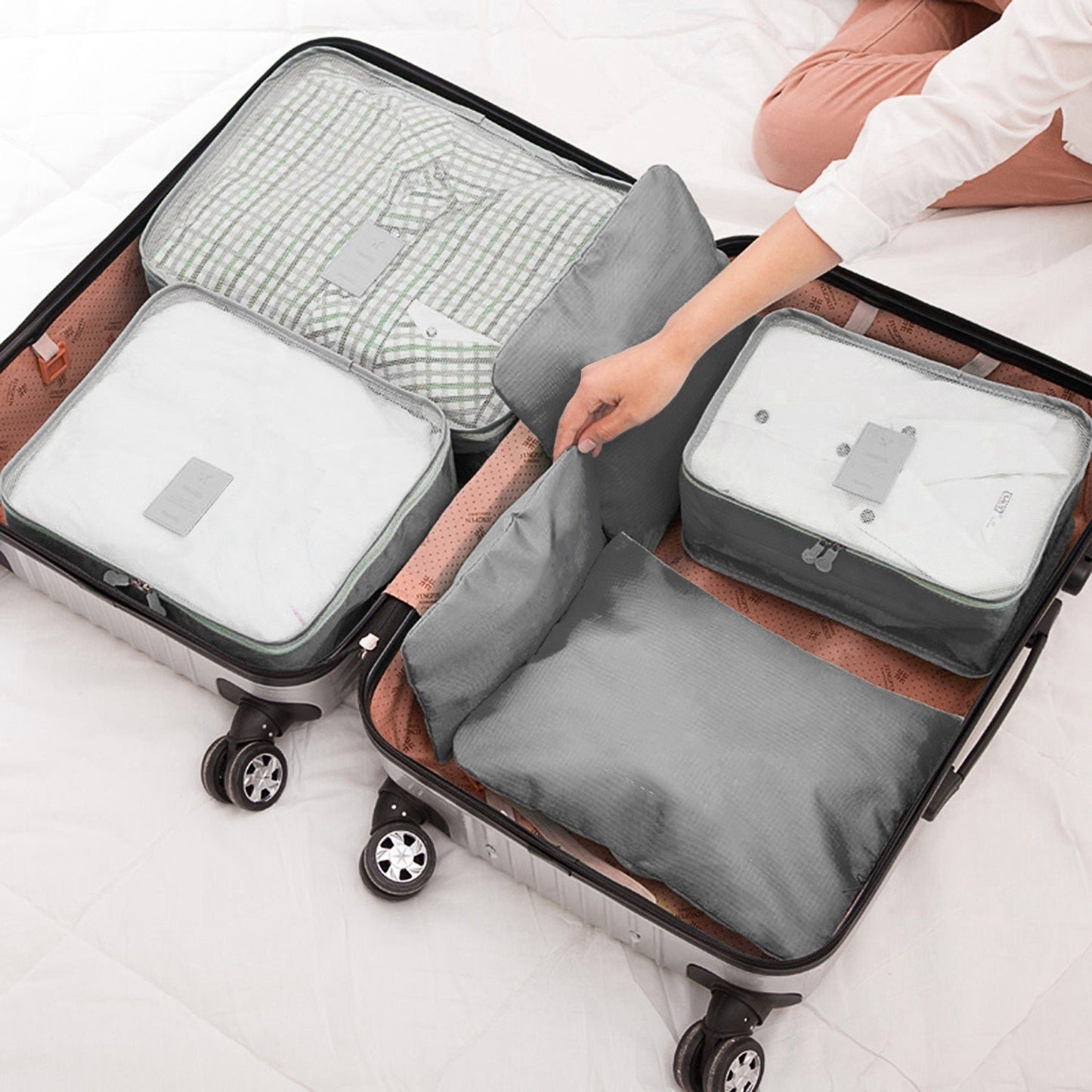 Gray packing cube set in a rolling suitcase with zip mesh panels and tags