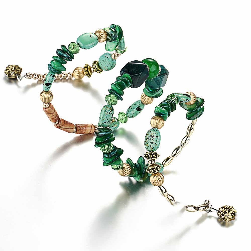 Boho charm bracelet set with green beads, wood accents, and gold-tone shell and flower charms.