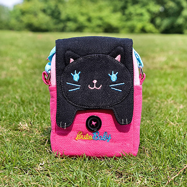 Cat swingpack bag with pink body, black flap, and embroidered eyes and Little Baby text.