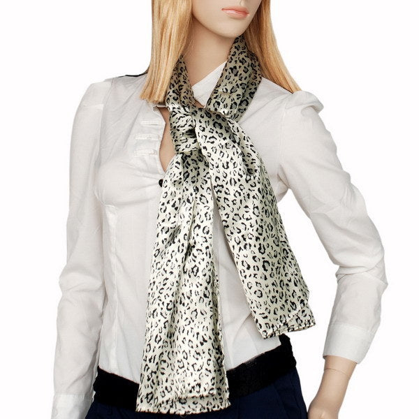 Leopard print silk scarf worn over a white blouse, long tails at chest.