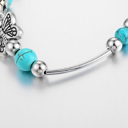 Silver-tone bracelet detail with turquoise beads and curved tube bar