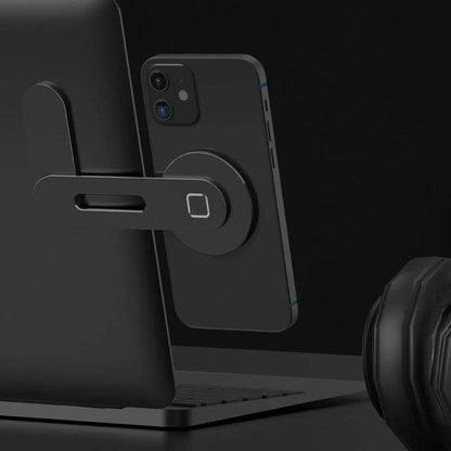 Dark magnetic phone holder with circular base mounted to a laptop