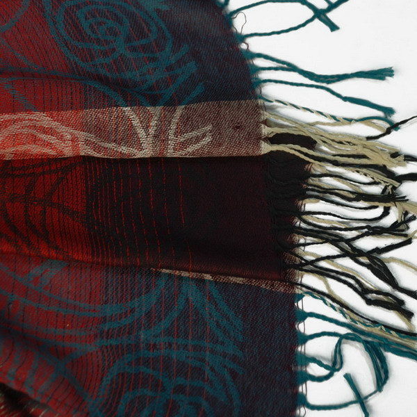 Pashmina shawl edge detail with multicolor woven pattern and dark tassels