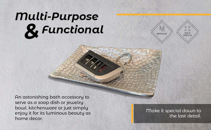 Rectangular hammered metal tray with a small dark accessory placed in the center