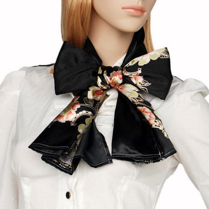 Black satin floral neck scarf with knotted bow and hanging ends on white shirt