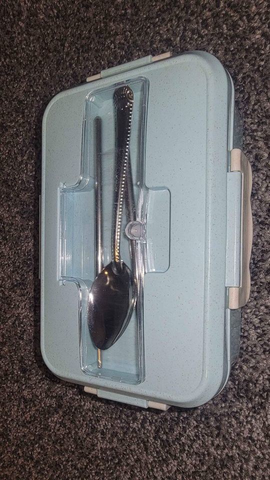 Blue bento box open with utensil holder and two compartments