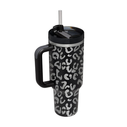 Vacuum insulated travel tumbler with leopard print in black and gray, featuring handle and straw lid.