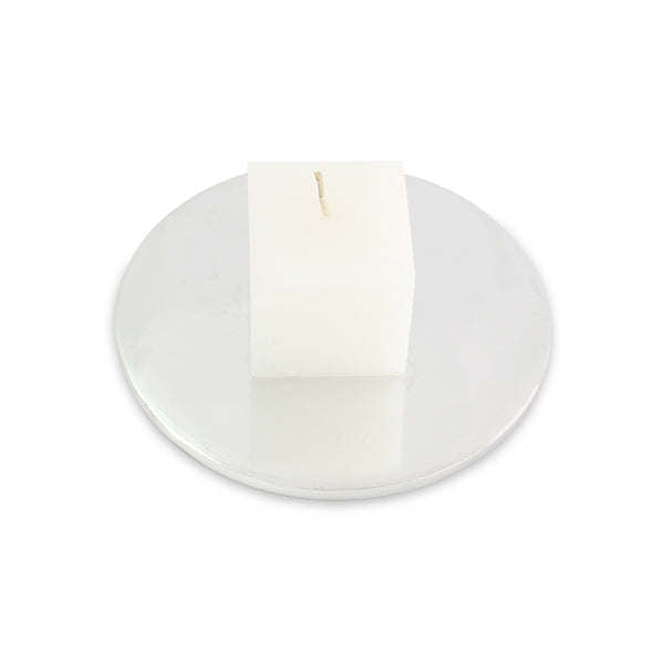 White pillar candle on round candle holder/coaster with smooth, minimalist design