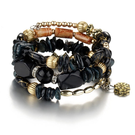 Multilayer boho charm bracelet with black stone-like beads and gold-tone accents