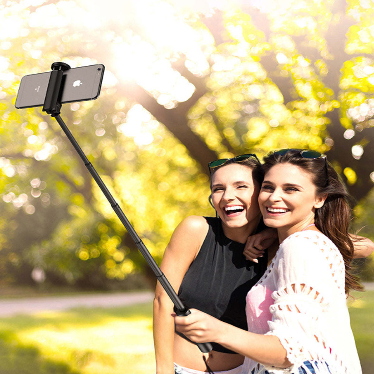 Black mini selfie stick with phone clamp extended for outdoor selfies