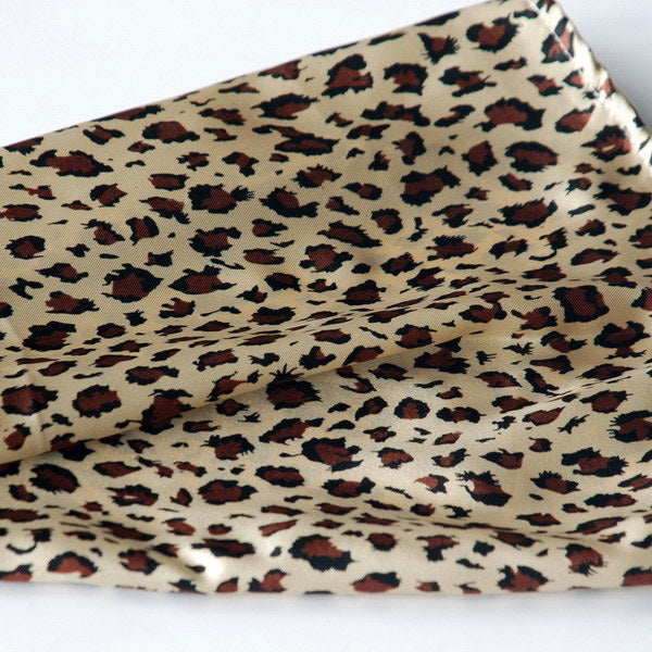 Brown leopard print scarf fabric close-up, soft woven pattern