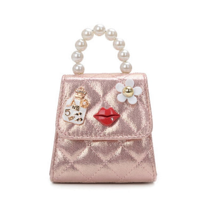 Pink metallic mini quilted crossbody bag with pearl handle and flower charm with red detail