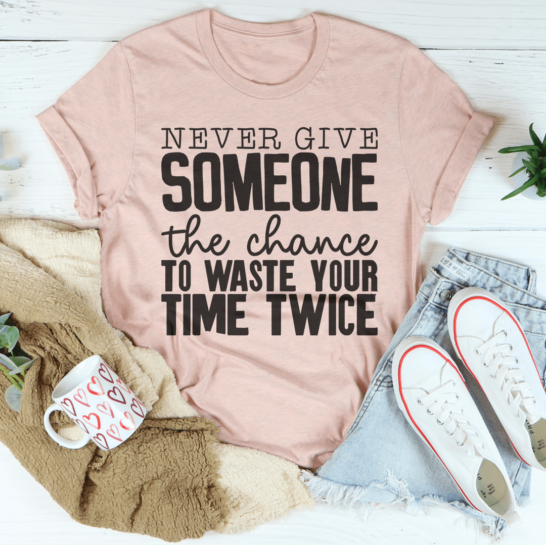 Heather pink crew-neck T-shirt with 'NEVER GIVE SOMEONE' and 'WASTE YOUR TIME TWICE'