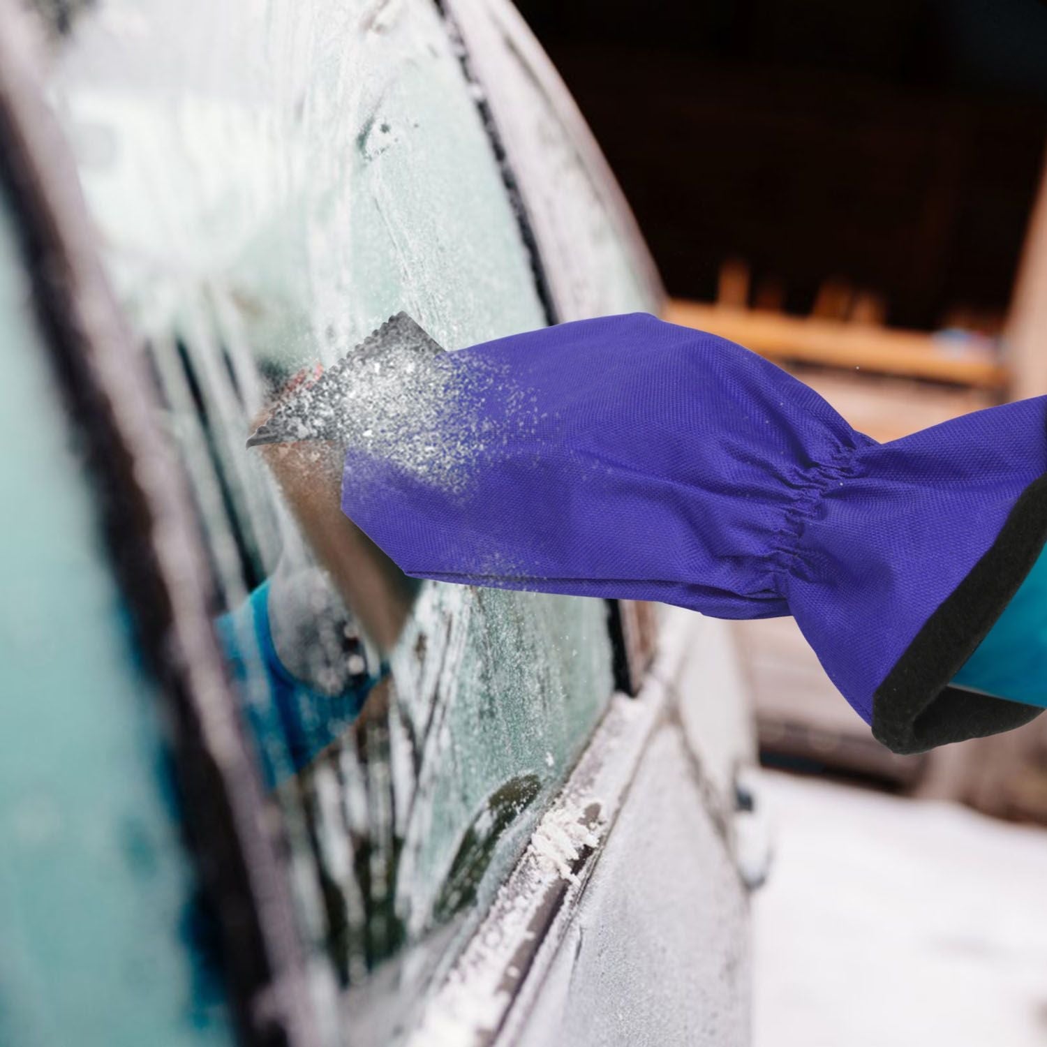 Purple ice scraper glove removing ice from car window with black blade