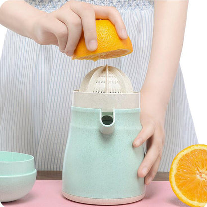 Green juicer base with strainer as orange half is pressed by hands