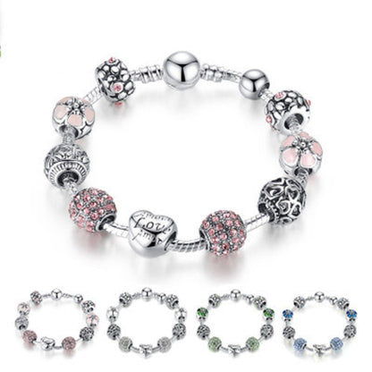 Silver-tone bead charm bracelet with heart, flower, and round spacer charms