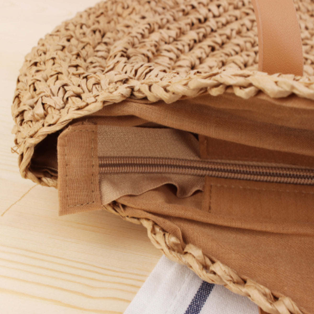Open straw tote bag showing tan lining and braided straw trim