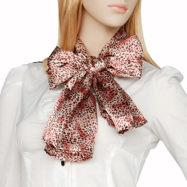 Warm pink leopard print silk scarf worn with bow-style knot at neck