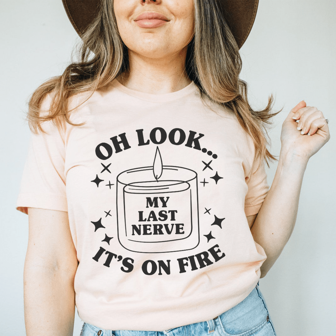 Light pink T-shirt on model with front candle graphic and “IT’S ON FIRE”