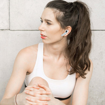 White Bluetooth earbuds in woman's ear with mic stems and blue status dots