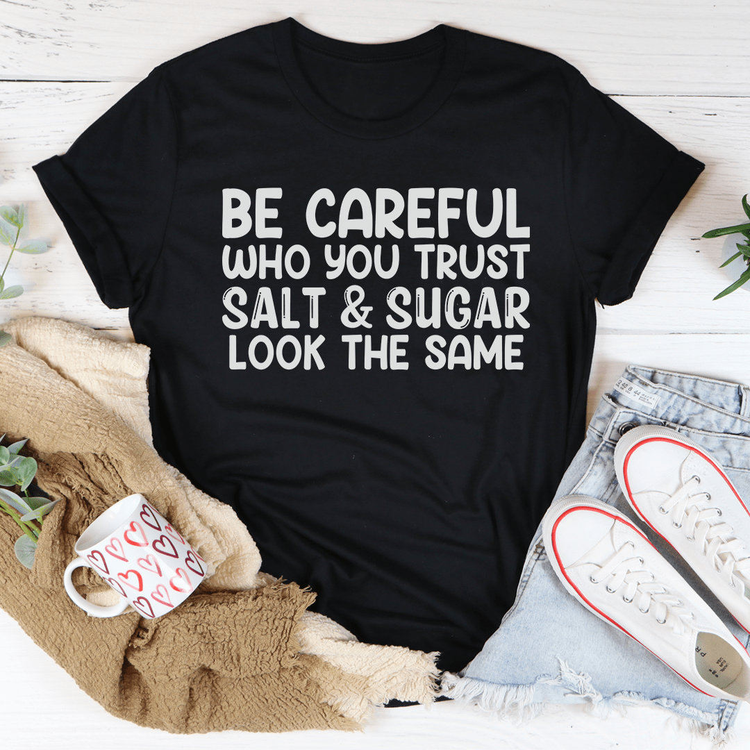 Black T-shirt with white stacked slogan graphic: “BE CAREFUL WHO YOU TRUST”