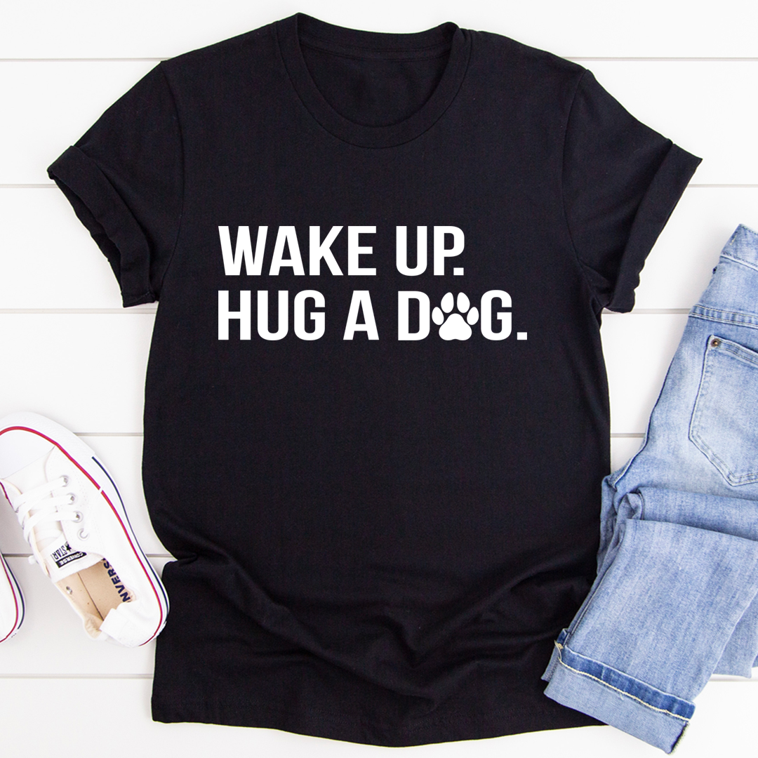 Black crewneck t-shirt with "WAKE UP. HUG A DOG" paw print graphic, front