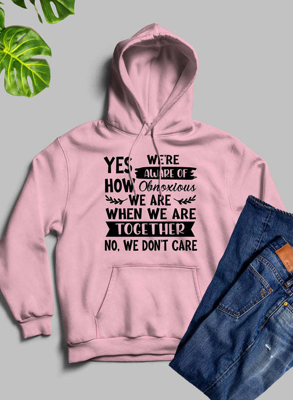 Pink pullover hoodie with hood and drawstrings, front slogan graphic text.