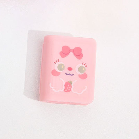 Pink book-shaped scrunchie eraser with cute face and bow graphic