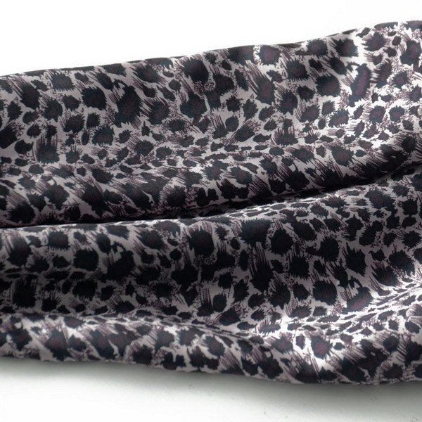 Close-up of leopard-print silk scarf fabric with dark purple and black tones