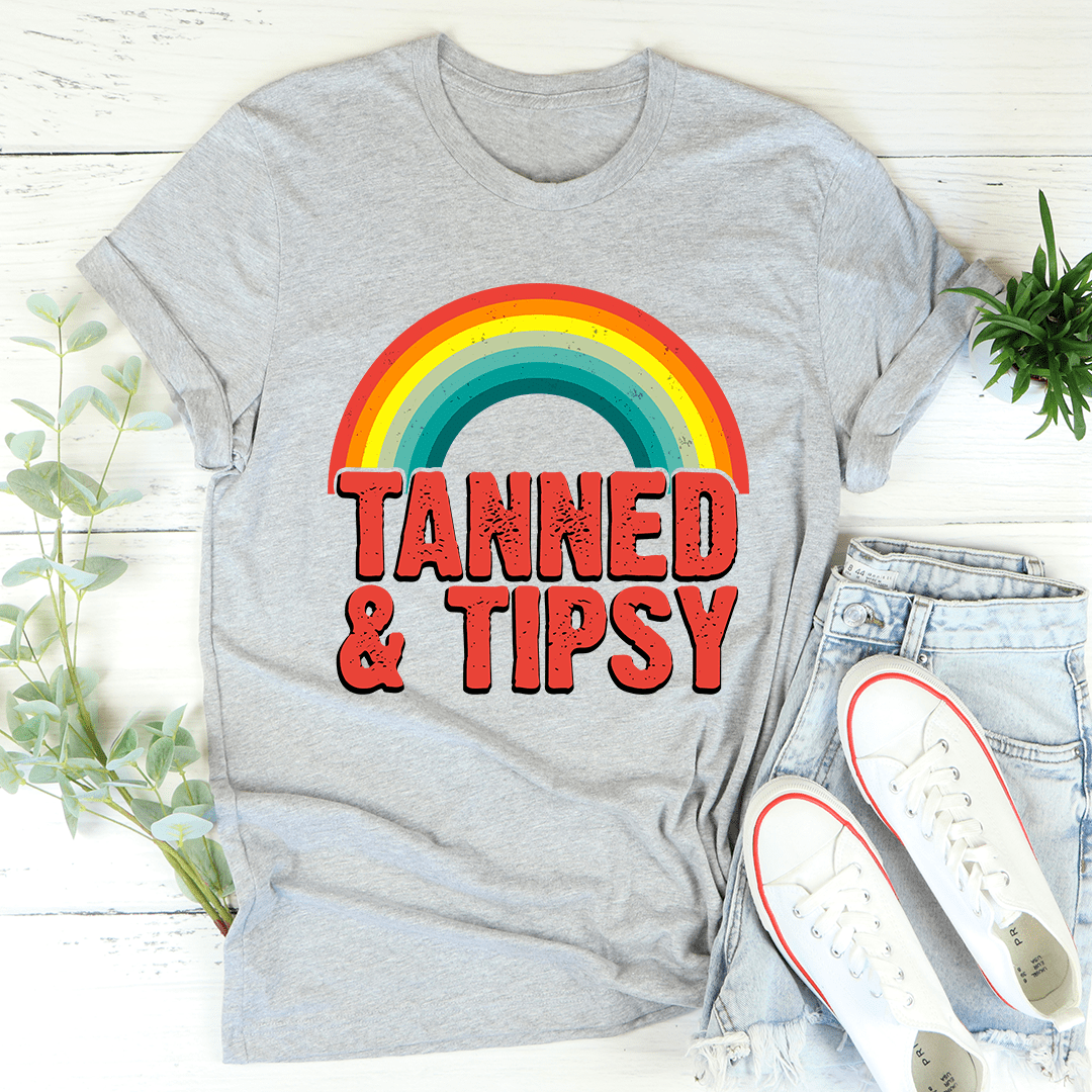 Heather gray T-shirt with rainbow graphic and red “TANNED & TIPSY” lettering