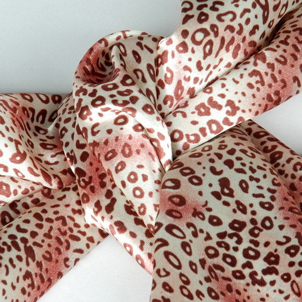 Warm pink leopard print silk scarf knot detail with twisted folds