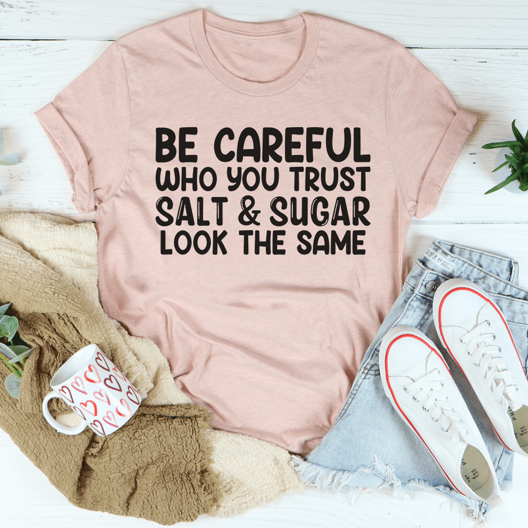 Mauve crew-neck graphic T-shirt with "BE CAREFUL WHO YOU TRUST" text