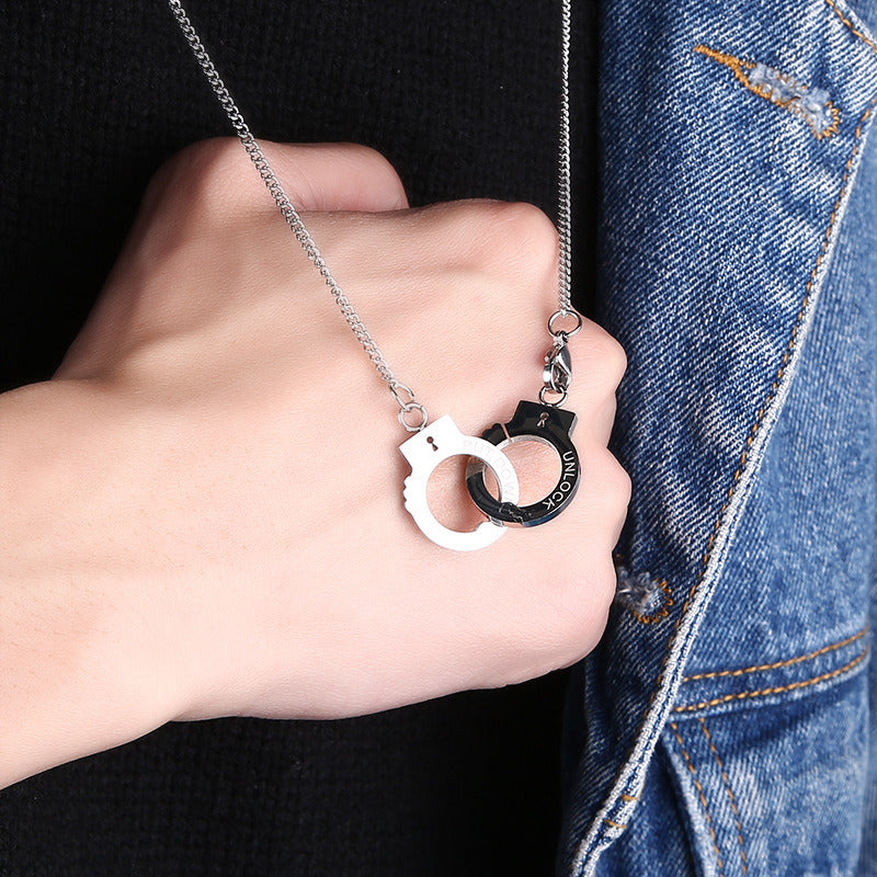 Handcuff pendant necklace held in hand, silver handcuff charm on chain
