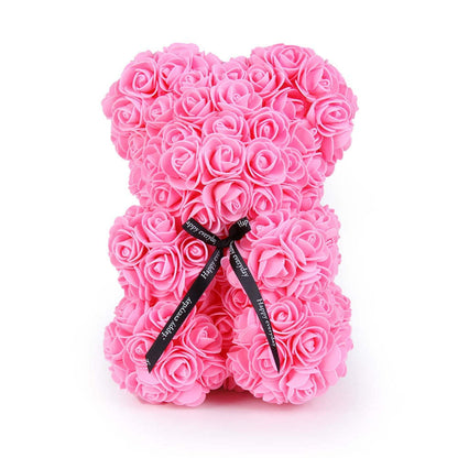 Pink rose teddy bear with dense rose petals and a black ribbon bow