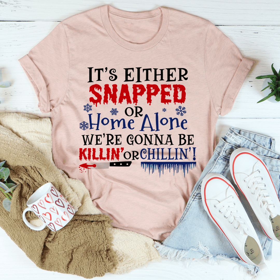 Blush pink Christmas T-shirt with large red and blue holiday slogan graphic.