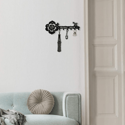 Black rose-pattern key hanger with four hooks and hanging accessories on wall