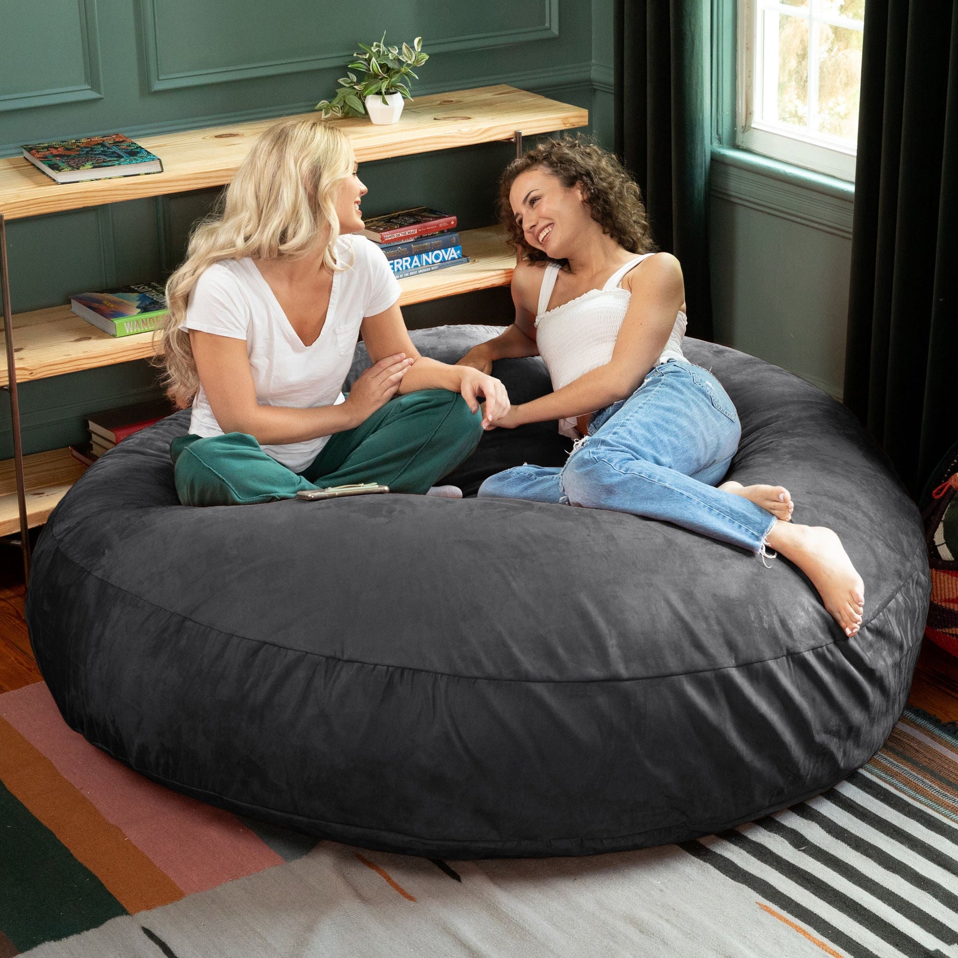 Black cocoon bean bag chair for lounging, large rounded microsuede seat