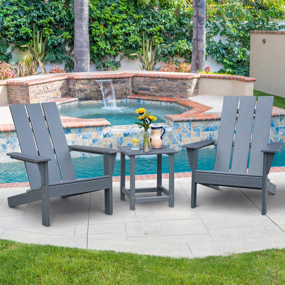 Dark grey outdoor Adirondack chairs with matching side table beside a swimming pool