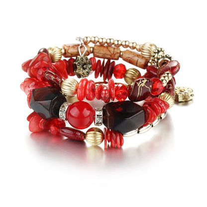 Red and black boho charm bracelet with faceted stones, red crystal beads, and gold-tone charms.