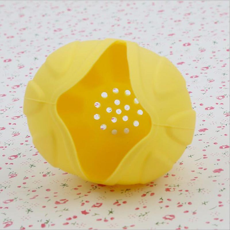 Yellow silicone citrus juicer press with perforated insert, open and ready