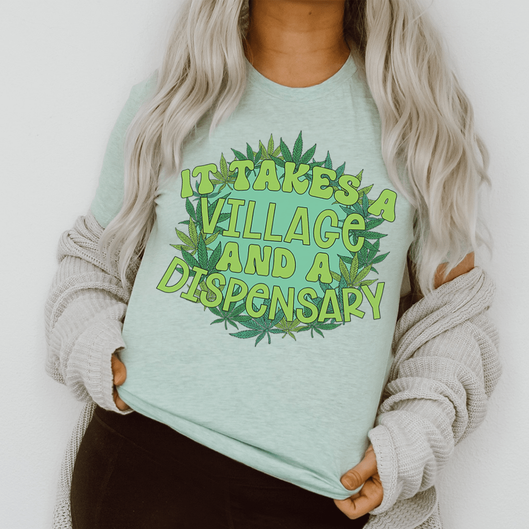 Light teal graphic T-shirt with green leaf text emblem, worn by model