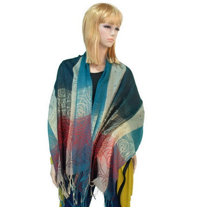 Pashmina shawl draped over shoulders in teal, red, and beige with tassel fringe ends
